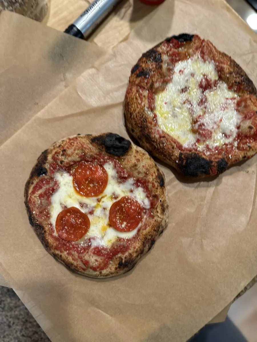 Freshly baked cheese and pepperoni pizzas on parchment